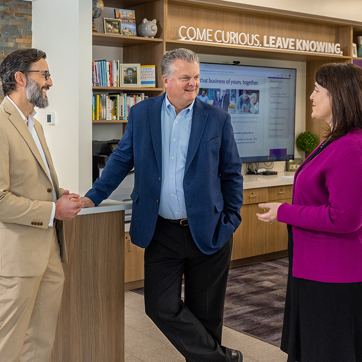 Three people talking in the Norwich Westside Branch of Averon Trust